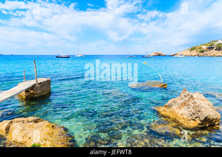 Petite jetée en bois dans la baie de Cala d'Hort et vue sur Es Vedra île, l'île d'Ibiza, Espagne Banque D'Images