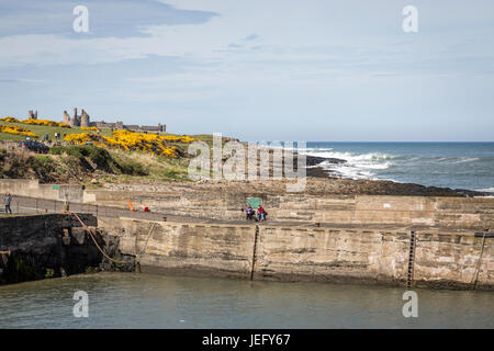 Vue sur Château De Dunstanburgh de Craster Harbour, Northumberland, Angleterre, Royaume-Uni, Europe. Banque D'Images