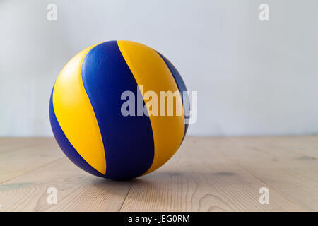 Bleu et jaune au volleyball sur plancher en bois Banque D'Images