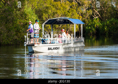 Un bateau de pêche avec les touristes sur l'eau jaune, le Parc National de Kakadu, Australie. Banque D'Images