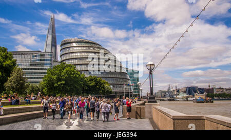 Les gens relaxer au bord de la Tamise avec le gratte-ciel Shard derrière. Le HMS Belfast navire se trouve sur la droite de la photo Banque D'Images