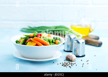 Mélanger les légumes dans le bol et sur une table Banque D'Images