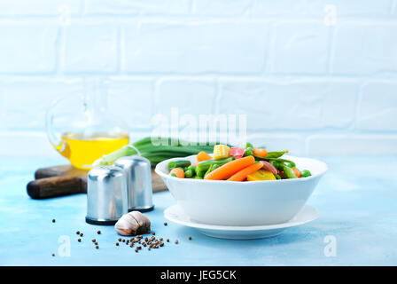 Mélanger les légumes dans le bol et sur une table Banque D'Images