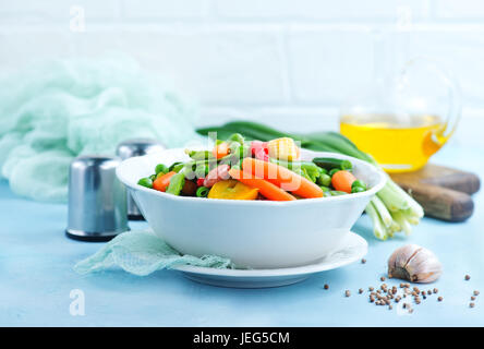 Mélanger les légumes dans le bol et sur une table Banque D'Images