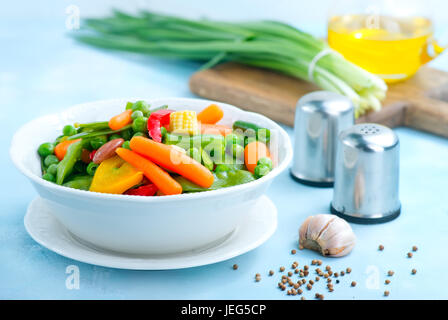 Mélanger les légumes dans le bol et sur une table Banque D'Images