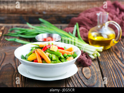 Mélanger les légumes dans le bol et sur une table Banque D'Images