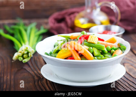 Mélanger les légumes dans le bol et sur une table Banque D'Images