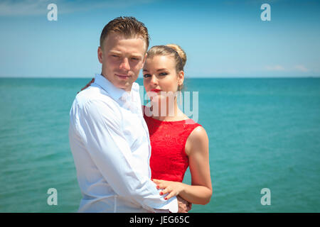 L'homme est une femme serrant delicatly posant avec elle par la mer. Portrait d'un beau couple en vacances. Banque D'Images