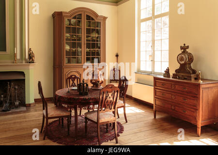 Old fashioned intérieur avec table, chaises, armoire murale en bois et de l'horloge. Historical Museum Bokrijk, Genk, Flandre orientale, Belgique Banque D'Images