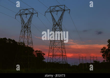 La tour de transmission de puissance silhouetted against sunset glow Banque D'Images