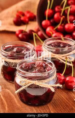 Confiture de cerises sur fond de bois dans les pots Banque D'Images