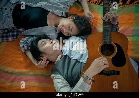 Des couples de jeunes asiatiques l'homme et de la femme qui joue de la guitare avec le repos et le bonheur de l'émotion Banque D'Images