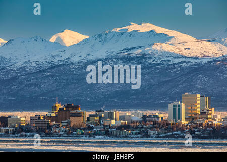 Vue sur le centre-ville d'Anchorage en hiver et les montagnes de Chugach enneigées au-delà vu de point Mackenzie, les Skies dans l'arrière-plan clair et ... Banque D'Images