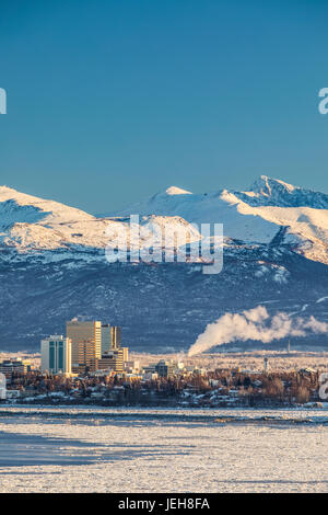 Vue sur le centre-ville d'Anchorage en hiver et les montagnes de Chugach enneigées au-delà vu de point Mackenzie, les Skies dans l'arrière-plan clair et ... Banque D'Images