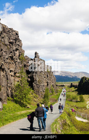 Les touristes à pied entre les plaques tectoniques eurasienne et américaine le long de la dorsale médio-atlantique en Islande Banque D'Images