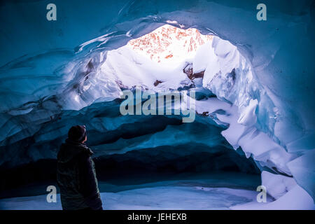 Un homme donne une ouverture dans le plafond d'une grotte de glace à l'intérieur de l'Augustana Glacier dans l'hiver, de l'Alaska, l'intérieur de l'Alaska, USA Banque D'Images