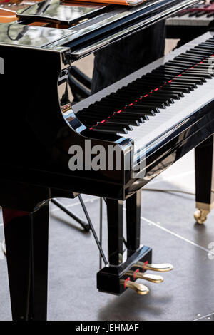 Piano à queue noir avec touches blanches et noires sur scène. vue rapprochée. Banque D'Images