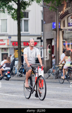 AMSTERDAM-AOÛT. 19, 2012. Homme à vélo à la place Dam. 38% du trafic dans la ville est en vélo, 37% en voiture, 25% en transports en commun. Banque D'Images