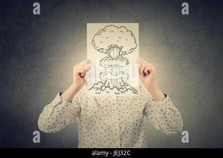 Young businessman holding a white paper sur sa tête avec un dessin d'explosion , isolé sur fond de mur gris.L'état mental de la dépression. Banque D'Images