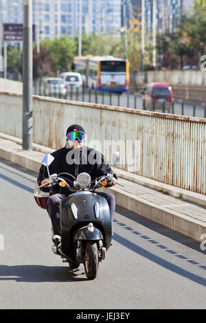 PÉKIN – OCTOBRE. 25, 2011. Homme sur un scooter électrique à Beijing. Actuellement, de nombreux résidents de Pékin achètent des scooters alimentés par batterie pour éviter de perdre du temps. Banque D'Images