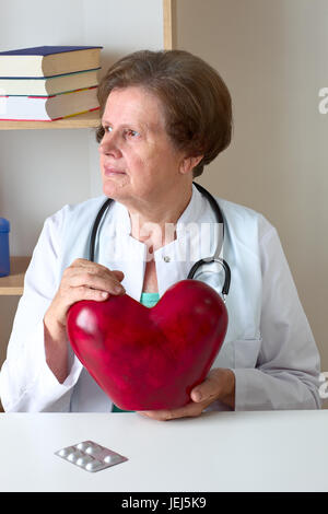 Femme médecin avec son stéthoscope holding heart. Banque D'Images