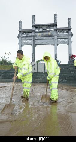 Fuliang, la province de Jiangxi. 25 Juin, 2017. Nettoyer la route des travailleurs à l'est de la Chine, du comté de Fuliang, province de Jiangxi, 25 juin, 2017. Jours de pluie torrentielle provoqué des inondations et des glissements de terrain dans de nombreuses régions du sud de la Chine, forçant l'évacuation de plus de 450 000 personnes. 19 East Shanshui Wen : Crédit/Xinhua/Alamy Live News Banque D'Images