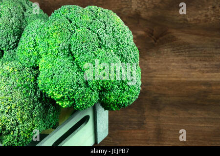 Les têtes de brocoli dans la caisse sur la texture rustique avec copyspace Banque D'Images