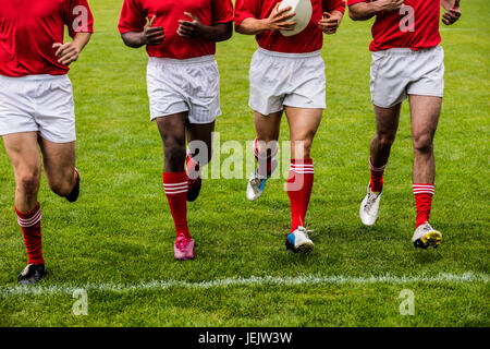 Jogging avec des joueurs de rugby ball Banque D'Images