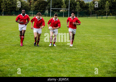 Jogging avec des joueurs de rugby ball Banque D'Images