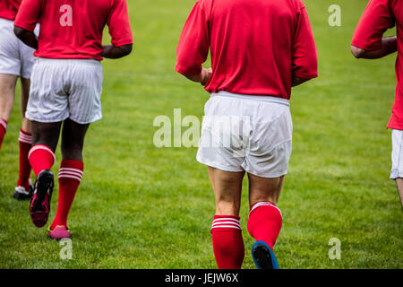 Jogging avec des joueurs de rugby ball Banque D'Images