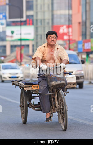 PÉKIN-10 JUILLET 2015. Homme sur le vélo de fret rouillé. Bien que les administrations municipales essaient de les interdire ce mode de transport est encore pratique. Banque D'Images