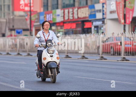 PÉKIN-10 JUILLET 2015. Femme sur un e-vélo. En dix ans, les vélos électroniques en Chine sont passés de près de zéro à plus de 150 millions d'ici 2015. Banque D'Images