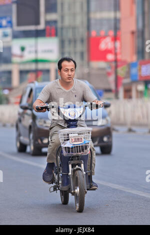 PÉKIN-10 JUILLET 2015. Homme sur un e-vélo. En dix ans, les vélos électroniques en Chine sont passés de près de zéro à plus de 150 millions d'ici 2015. Banque D'Images