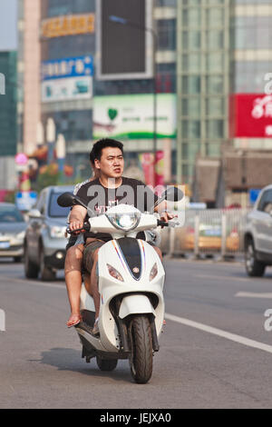 PÉKIN-24 JUILLET 2015. Couple sur scooter électrique. En dix ans, les vélos électroniques en Chine sont passés de près de zéro à 150 millions (2015). Banque D'Images