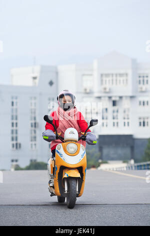 WENZHOU-17 novembre 2014. Femme sur un e-bike. On estime à 200 millions de Chinois utilisent maintenant des e-bikes, 1 000 fois plus qu'il y a 15 ans. Banque D'Images