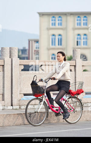 WENZHOU-17 novembre 2014. Jolies femmes sur un vélo. Vie des femmes en Chine ont beaucoup changé après le gouvernement fait des efforts sur l'égalité des sexes. Banque D'Images