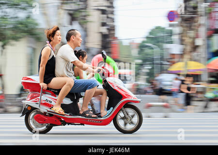 XIANG YANG-CHINE AU 3 JUILLET 2012. Couple avec leur enfant sur un scooter. La politique de planification familiale de la Chine limite officiellement d'avoir un enfant. Banque D'Images