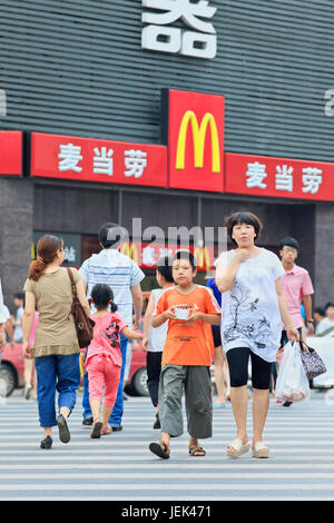 XIANG YANG-CHINE AU 3 JUILLET 2012. Maman et son fils en face de McDonalds de courant. Il a fallu 19 ans pour arriver à McDonalds 1 000 restaurants en Chine. Banque D'Images