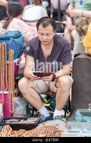 PÉKIN-29 MAI 2016. Vendeur sur le marché de Panjiayuan. Le plus grand marché vendant des antiquités, des métiers d'art, des objets de collection et des décorations en Chine. Banque D'Images