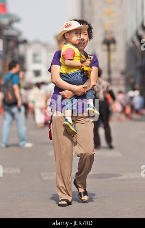 PÉKIN-9 JUIN 2015. Femme chinoise aînée avec petit-fils. Pour aider leurs enfants, les personnes âgées chinoises jouent souvent un rôle actif dans la collecte de petits-enfants. Banque D'Images