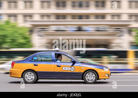 PÉKIN-4 MAI 2016. Taxi avec bus sur fond. Le nombre de taxis de Pékin est plus élevé que dans de nombreuses autres villes du monde. Banque D'Images