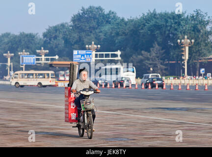 PÉKIN-1 JUIN 2013. Le travailleur transporte des petits pains de gaze sur sa moto électrique tôt le matin. La Chine compte actuellement 150 millions de vélos électriques. Banque D'Images