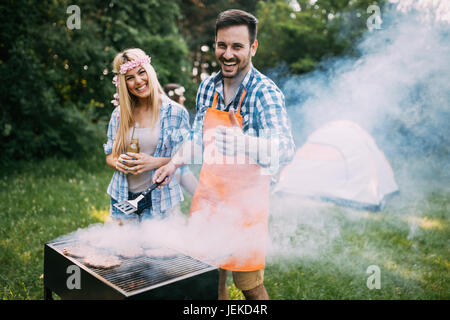 Jeune femme belle et bel homme having barbecue Banque D'Images