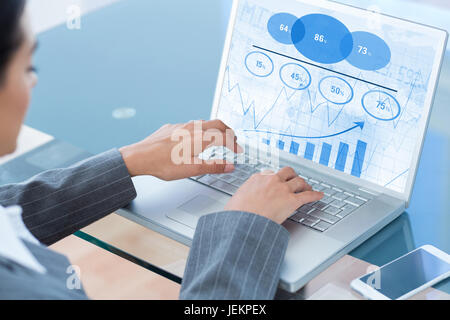 Image composite de businesswoman using laptop Banque D'Images