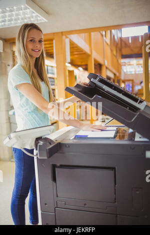 Smiling blonde faisant une copie d'étudiant Banque D'Images
