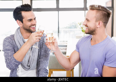 Smiling gay couple toasting with champagne Banque D'Images