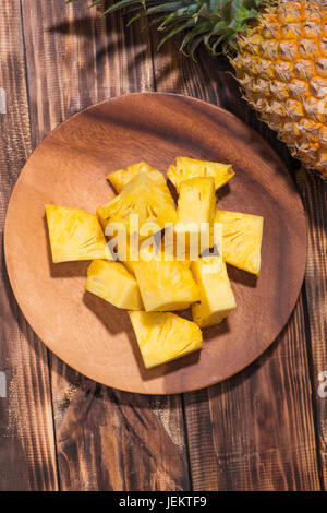 Concept de fruits tropicaux. Ananas coupés sur le vieux fond de bois. Banque D'Images