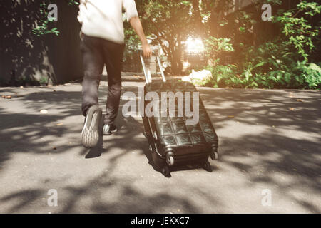 Jeune homme et de voyage assurance suitcase walking Banque D'Images