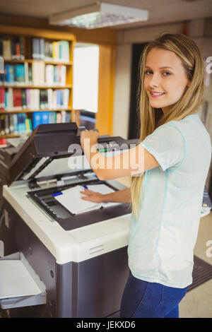 Smiling blonde faisant une copie d'étudiant Banque D'Images