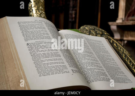 Un texte religieux sur un golden eagle head stand livre podium, donnant sur de vastes quantités de coin. Banque D'Images